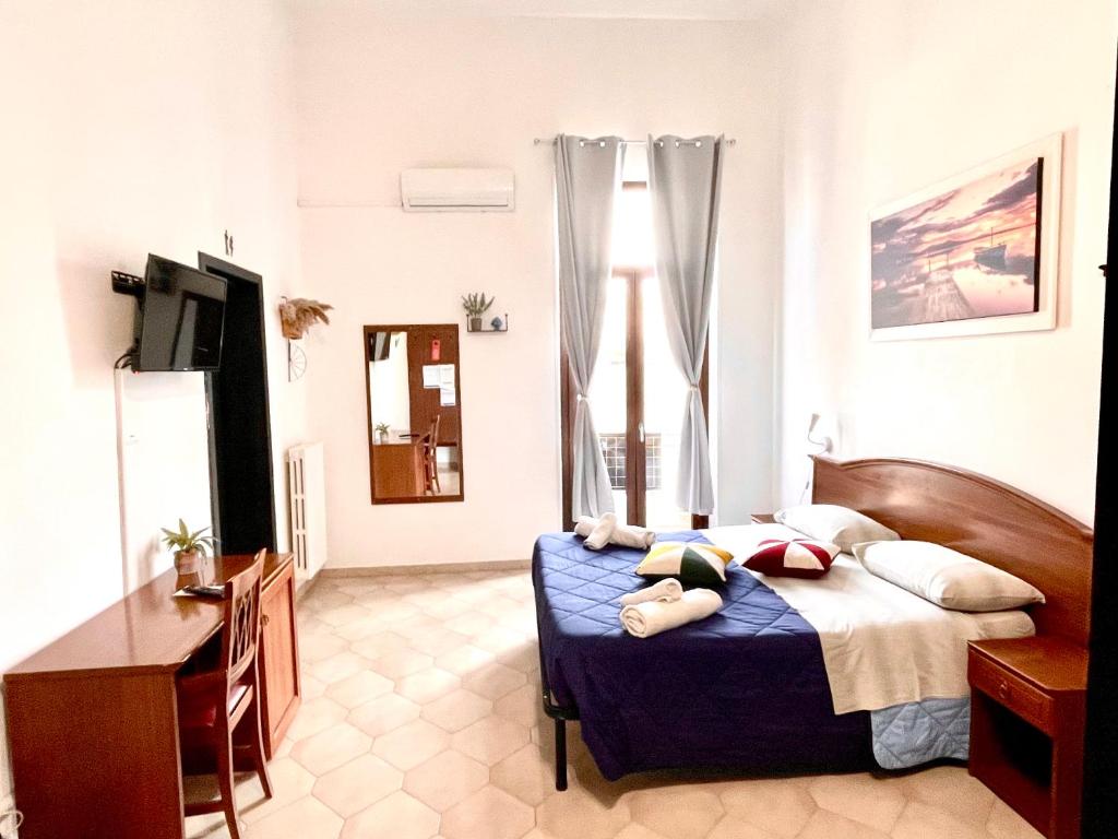 a bedroom with a bed and a desk and a television at B&B station in Brindisi