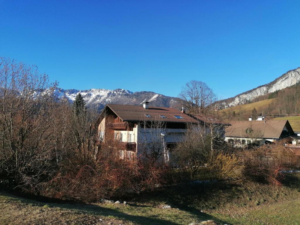 een huis in een veld met bergen op de achtergrond bij Alpenblumal in Bad Goisern