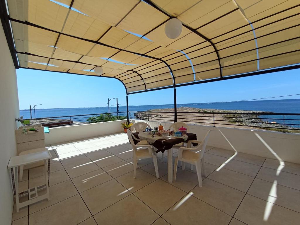 een eetkamer met een tafel en uitzicht op de oceaan bij Casa dei Glicini in Nardò