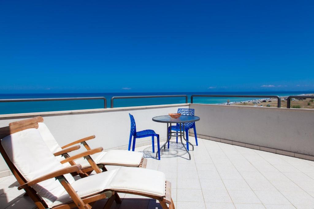 a balcony with chairs and a table and the ocean at La Terrazza sul Mare in SantʼAgata di Militello