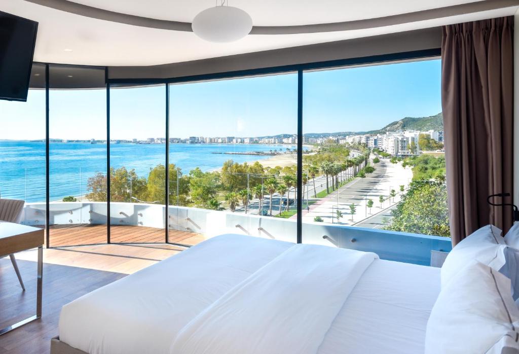 發羅拉的住宿－Yacht Hotel，一间卧室配有一张床,享有海景