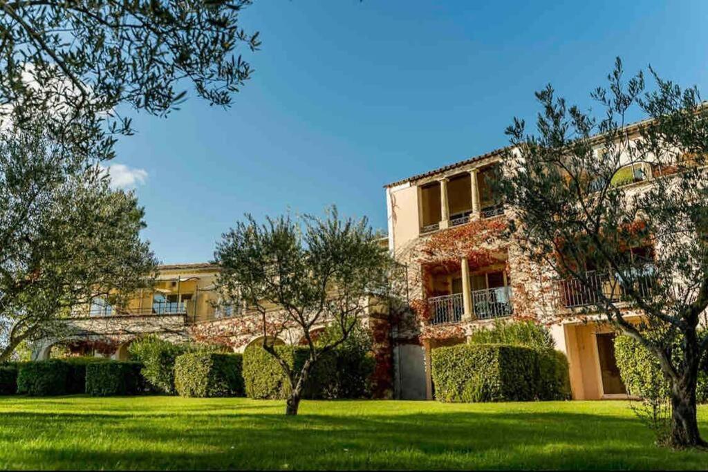 un grand bâtiment avec une pelouse devant dans l'établissement Moment de détente sur le Golf de Pont-Royal, à Mallemort