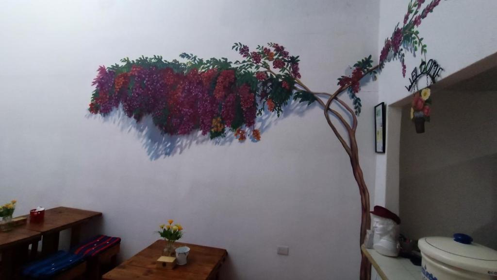 baño con una pintura floral en la pared en Hotel Posada Don Papagon, en Antigua Guatemala