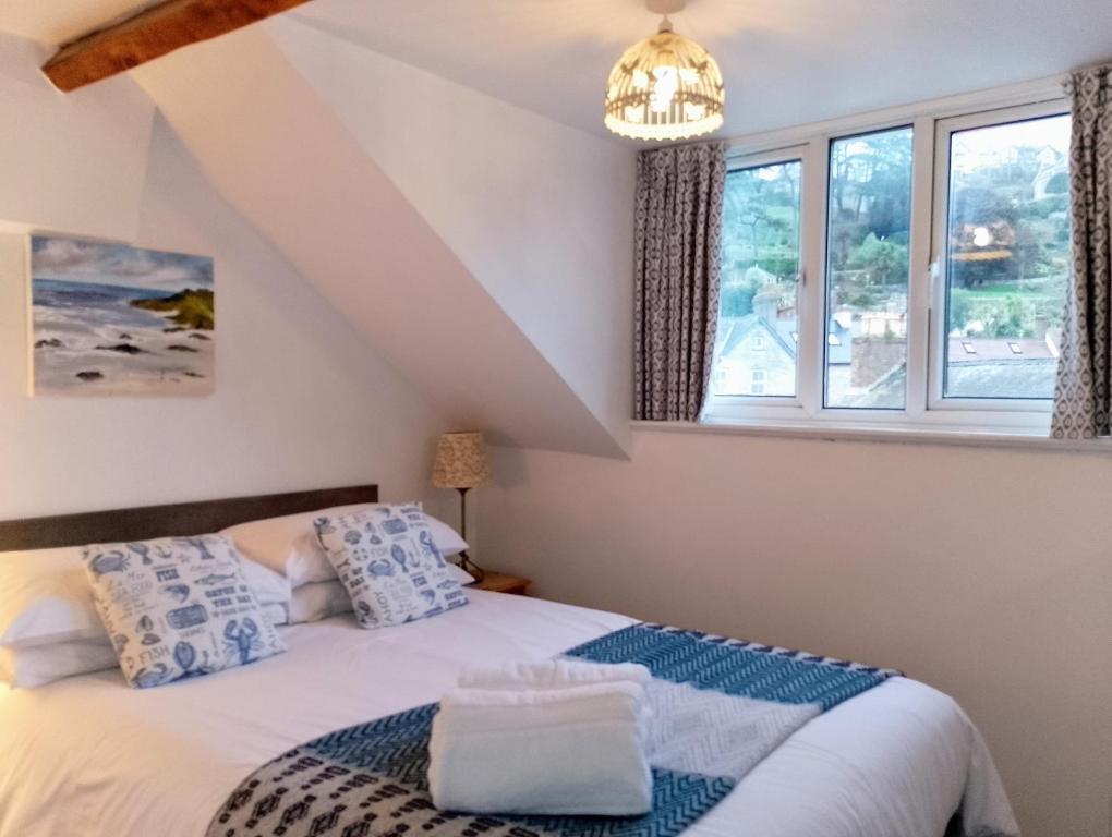 ein Schlafzimmer mit einem Bett und zwei Fenstern in der Unterkunft Durham House in Beer