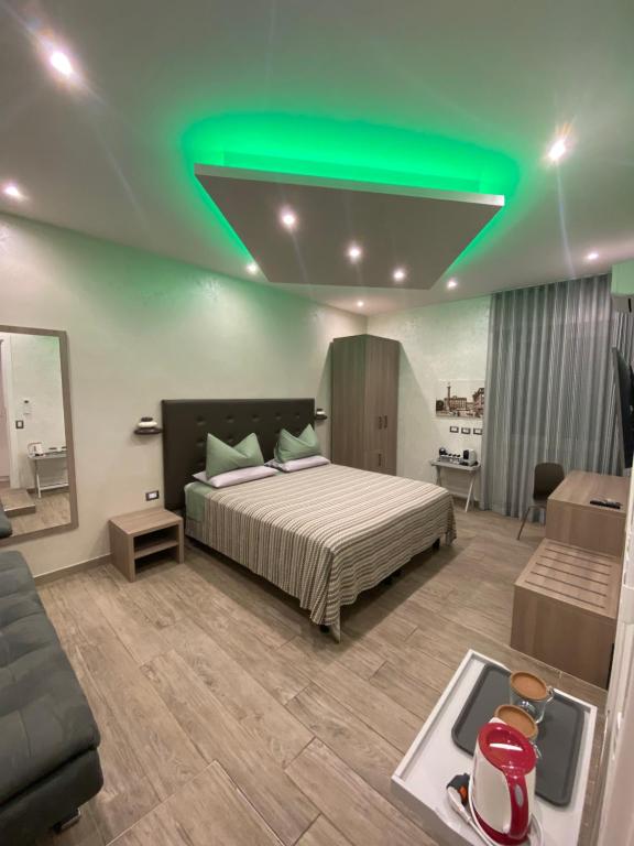 Schlafzimmer mit einem Bett mit grünem Licht an der Decke in der Unterkunft Domus Cinecittà in Rom
