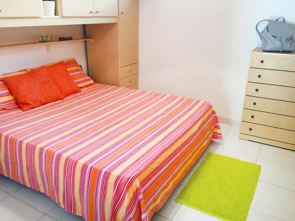 ガリポリにあるRobinia Apartment - Gallipolitravelのベッドルーム1室(オレンジ色の枕とドレッサー付きのベッド1台付)
