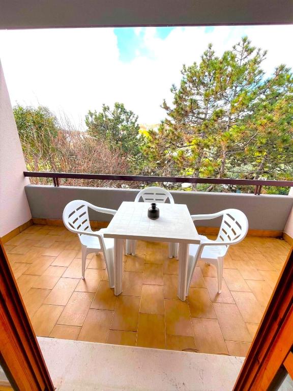 シローロにあるGIULY - appartamenti con terrazzo in centro a Siroloの白いテーブルとバルコニー(椅子2脚付)