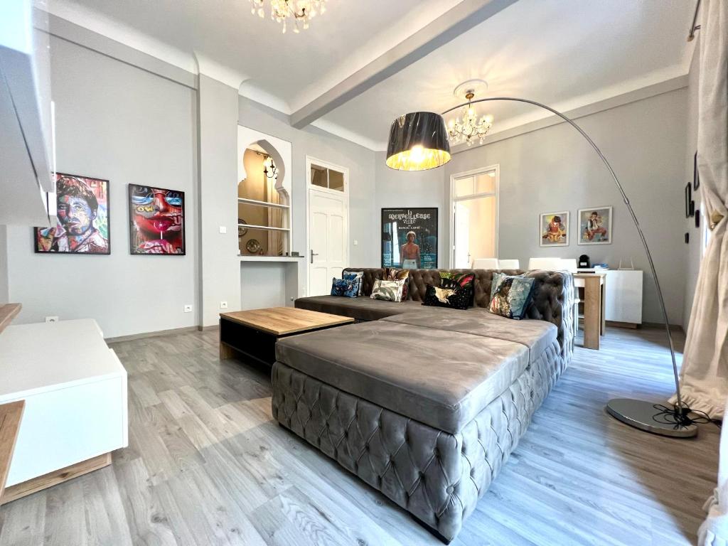 a living room with a large bed and a couch at Le Parisien - Chic 2BR City Centre Escape in Tangier