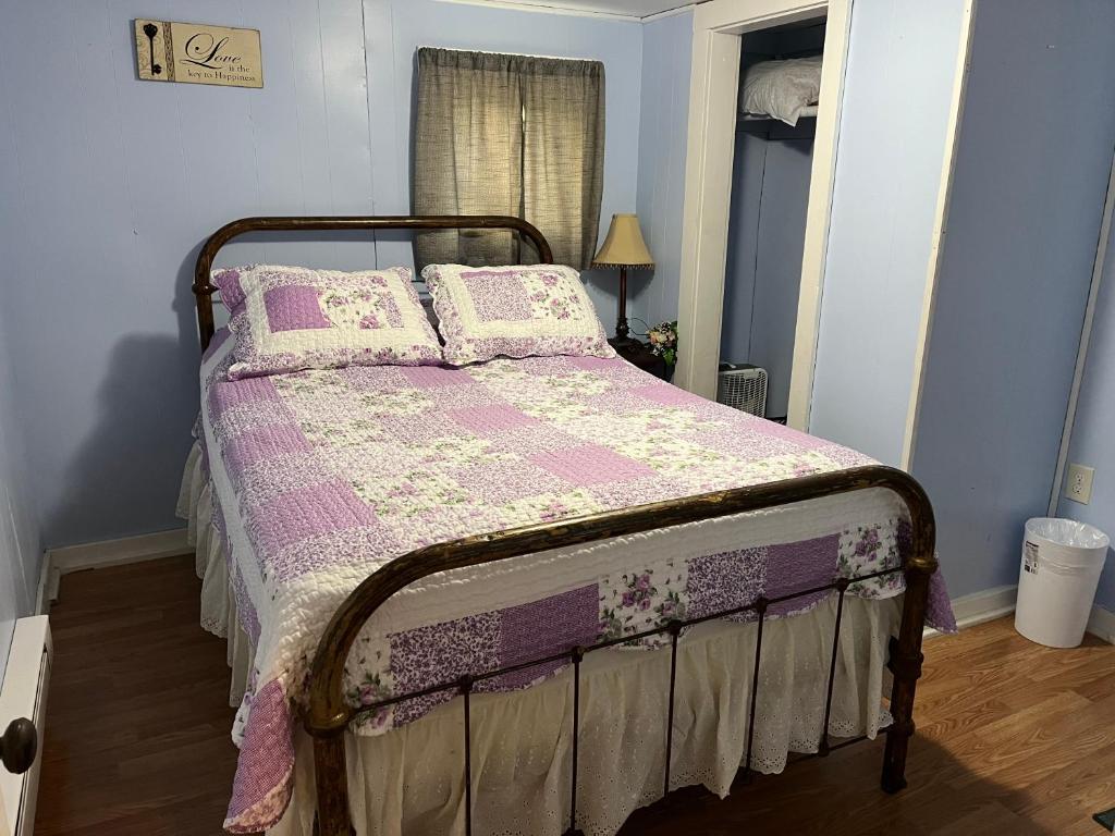 a bedroom with a bed with a pink blanket and pillows at Cochran Farm House in Bryson City