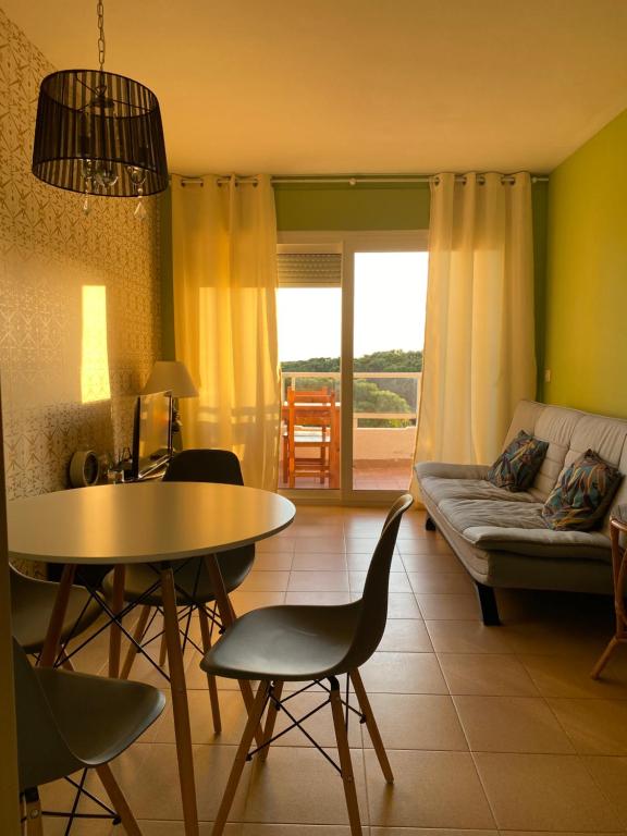 ein Wohnzimmer mit einem Tisch und einem Sofa in der Unterkunft Apartamento MARINA PLAYA, primera linea de mar in Blanes