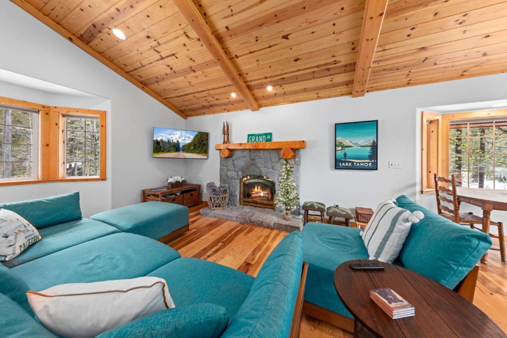 sala de estar con sofás azules y chimenea en Tahoe Grand on the West Shore - Pet Friendly & Hot Tub!, en Homewood