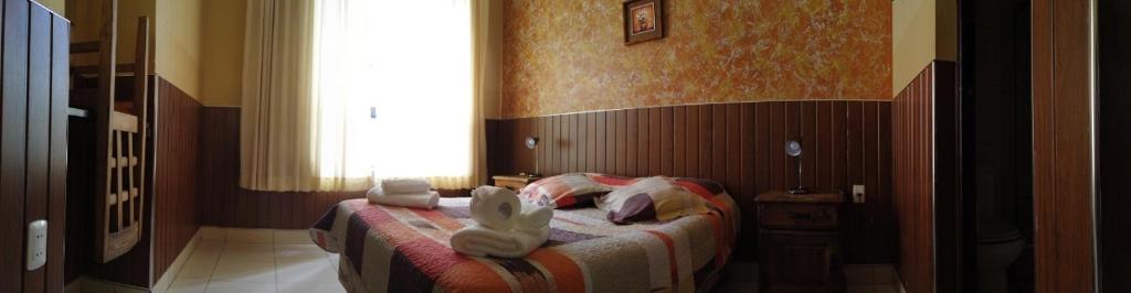 a bedroom with a bed with towels on it at Mitru Express Tupiza in Tupiza