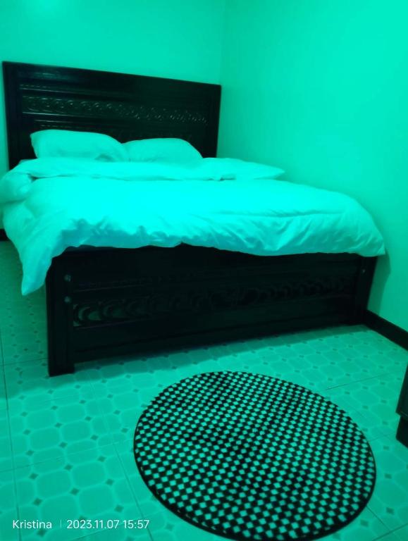 een blauwe slaapkamer met een bed met een zwart hoofdeinde bij Christie's apartments Buruburu in Nairobi