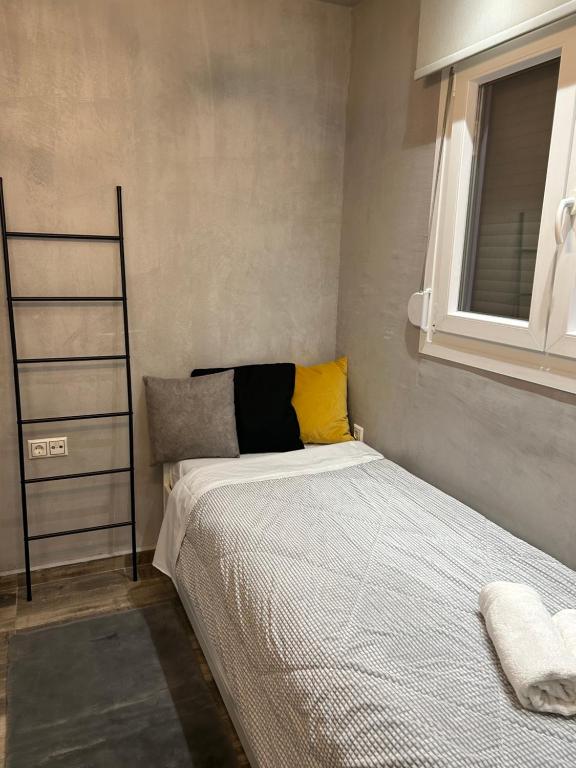 a small bedroom with a bed and a window at Overwave Apartment in Kavála