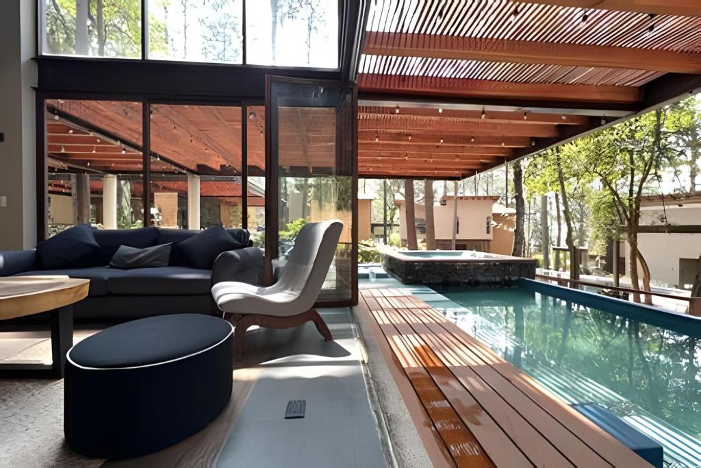 a living room with a swimming pool and a house at Casa con alberca y jacuzzi in Avándaro