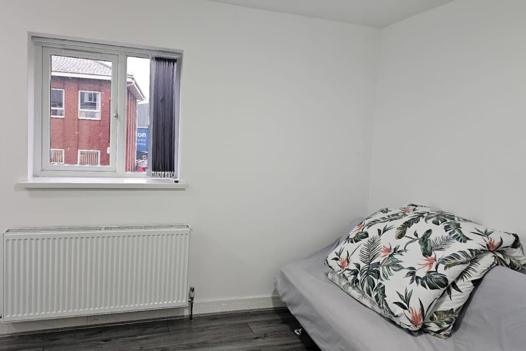 Cama con almohada en habitación con ventana en Two Bedroom Apartment at Oldbury with side road parking, en Oldbury