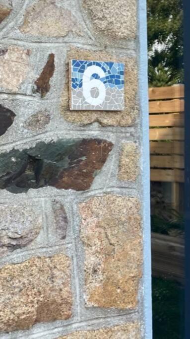 a stone wall with a number sign on it at Ty glaz in Ploubazlanec