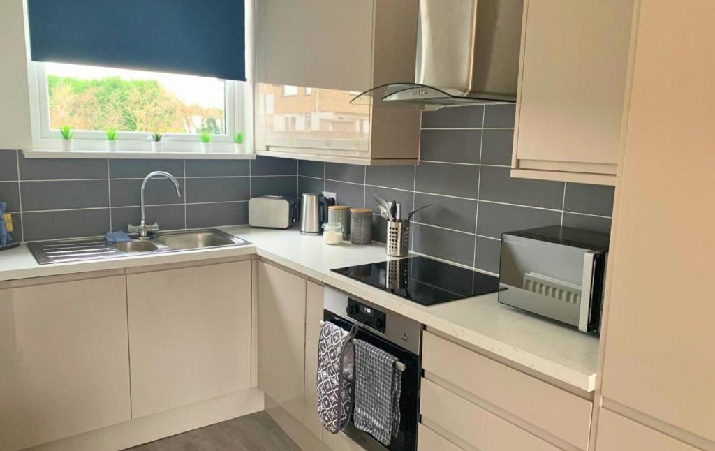 a kitchen with a sink and a stove top oven at Shotley Bridge - Stunning 2 bedroom apartment in Consett