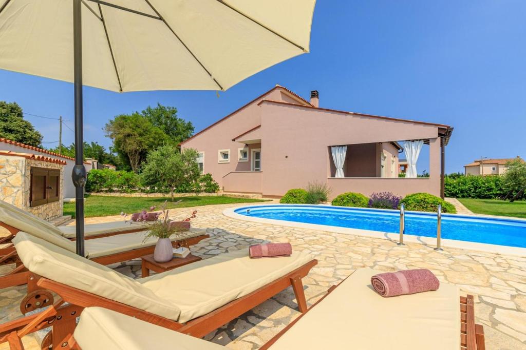 a villa with a swimming pool and a house at Villa Agri with large Garden and Pool near Pula in Loborika