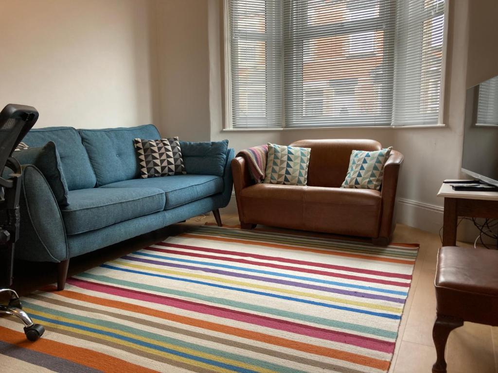 a living room with a couch and a chair at 3 bedroom Victorian house close to City centre in Exeter