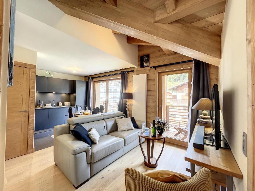 een woonkamer met een bank en een tafel bij STELLA - Les Gets - Centre village in Les Gets
