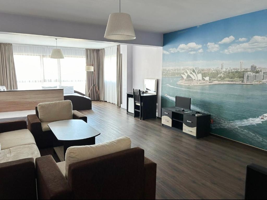a living room with a large painting of a harbour at Meatsa Hotel in Kŭrdzhali