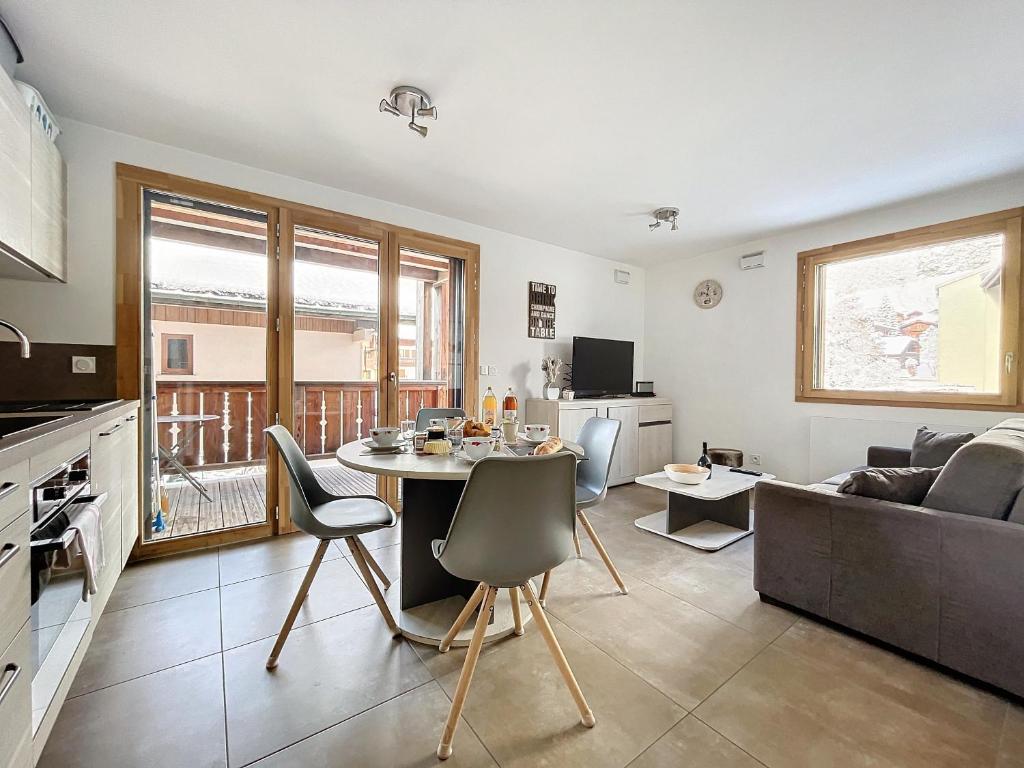 une cuisine et un salon avec une table et un canapé dans l'établissement AMBRE BLANCHE A106 - Les Gets - Centre village, aux Gets