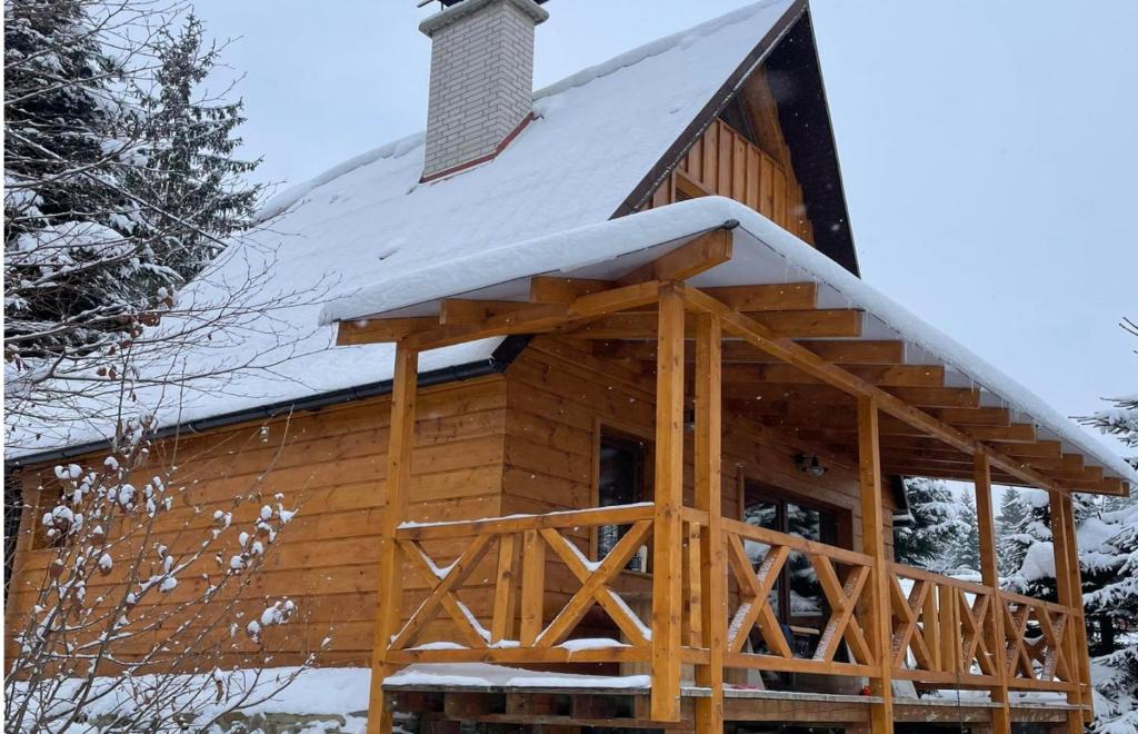 eine Blockhütte mit Schnee auf dem Dach in der Unterkunft Chata na Soláni in Vsetín