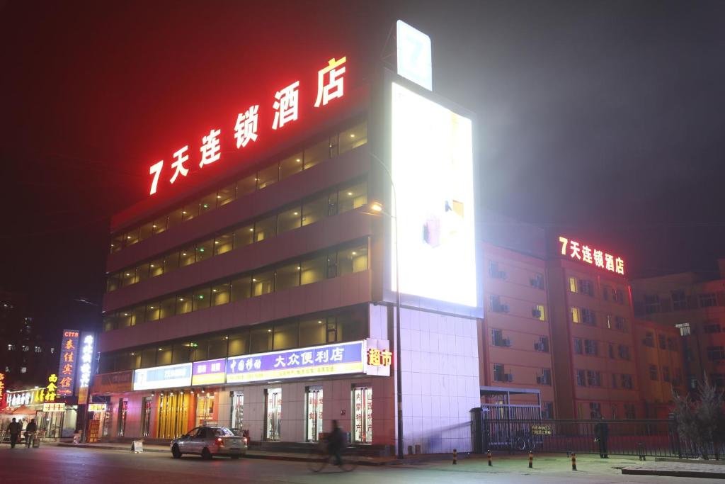 a large building with neon signs on the side of it at 7Days Inn Datong Railway Station in Datong