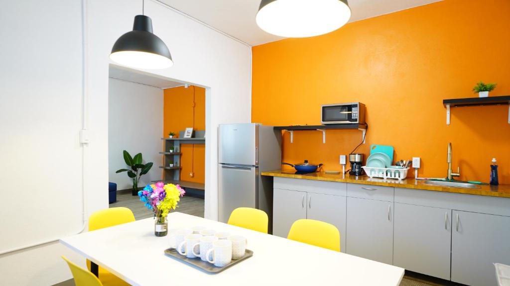 a kitchen with orange walls and a table and a refrigerator at Caribbean Stars in Carolina