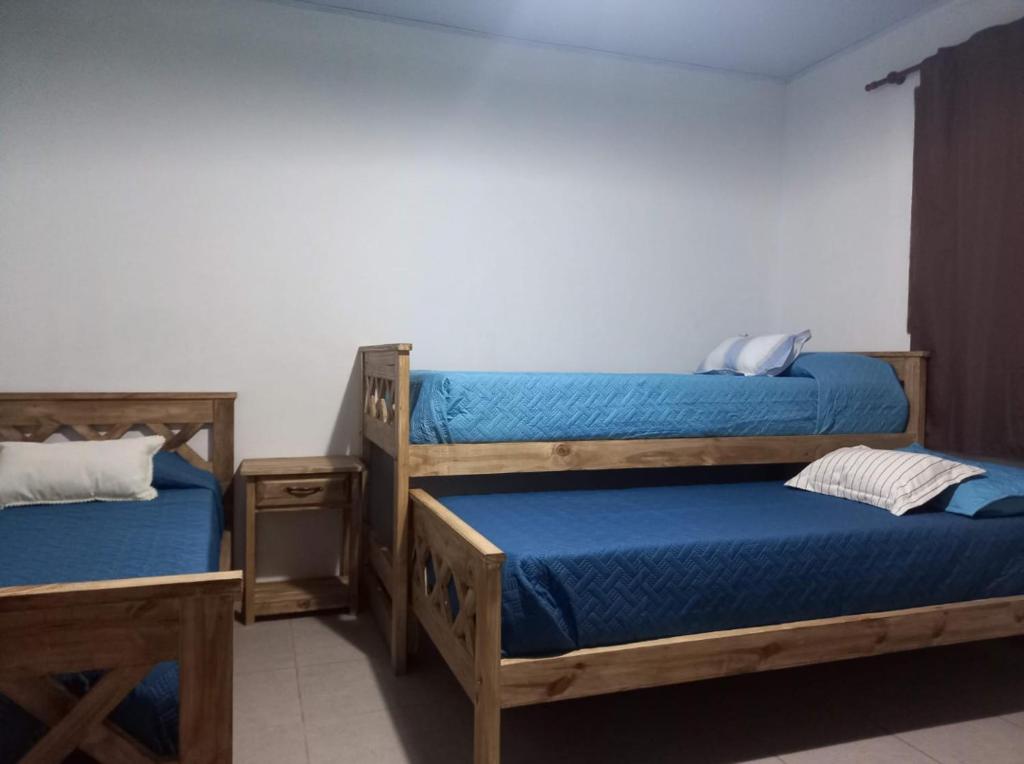 1 dormitorio con 2 literas con sábanas azules en El Molino cabañas en General Juan Madariaga