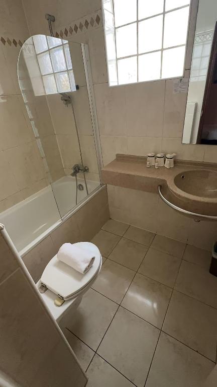 a bathroom with a toilet and a shower and a sink at 121 Paris Hotel in Paris