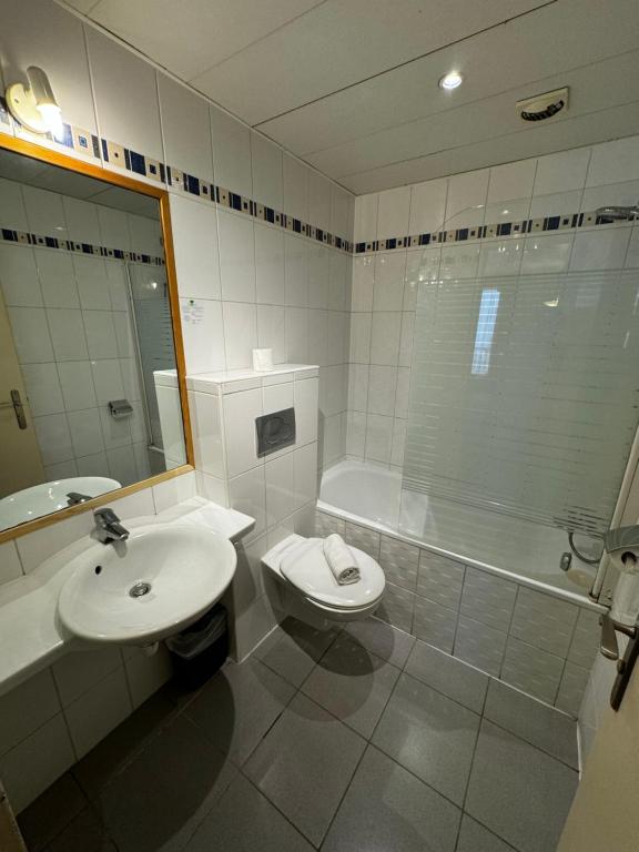 a bathroom with a sink and a toilet and a tub at 121 Paris Hotel in Paris