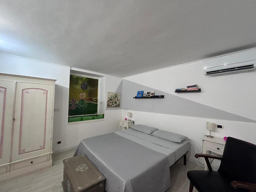 1 dormitorio blanco con 1 cama y 1 silla en APT a due passi da San Pietro, en Roma
