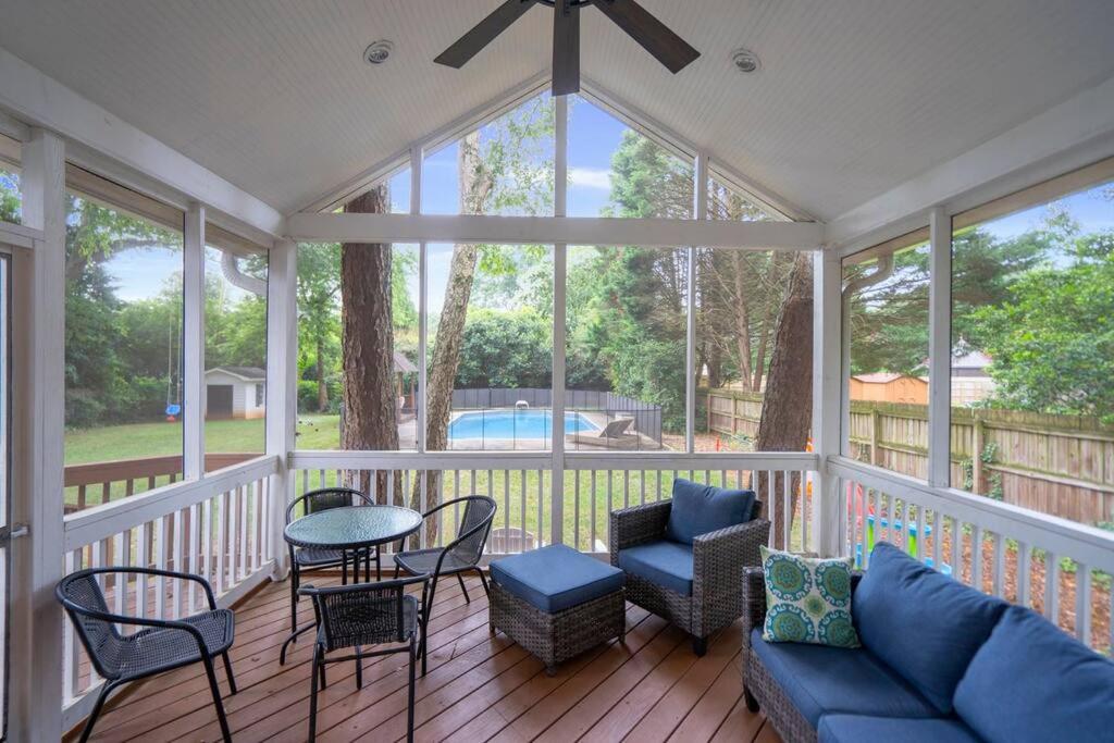a screened in porch with a couch and chairs and a table at Cozy Home w/ POOL + BABY Gear in Prime Area in Charlotte