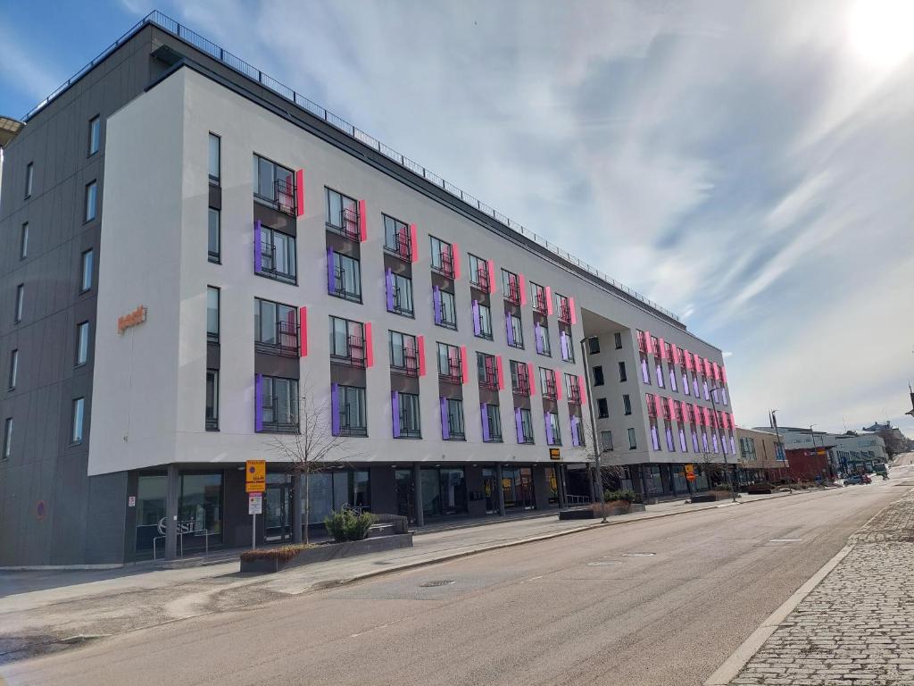 un gran edificio blanco con ventanas rojas en una calle en Kotimaailma Apartments Vapaudenkatu 48-50 B51 en Jyväskylä