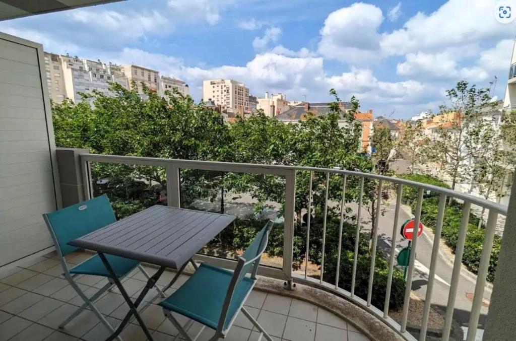 une table et des chaises sur un balcon avec vue sur une ville dans l'établissement LES DUNES DE BLOSSAC 100m de la plage avec garage, à Les Sables-dʼOlonne