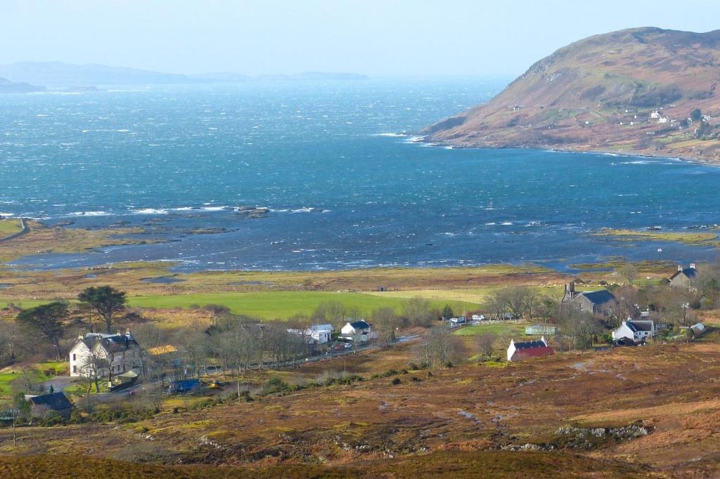 a small village on a hill near the ocean at Kilchoan Hotel in Kilchoan