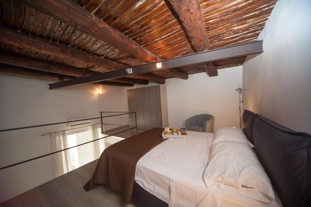 sypialnia z łóżkiem i drewnianym sufitem w obiekcie Home Salvator Rosa 78 w mieście Neapol