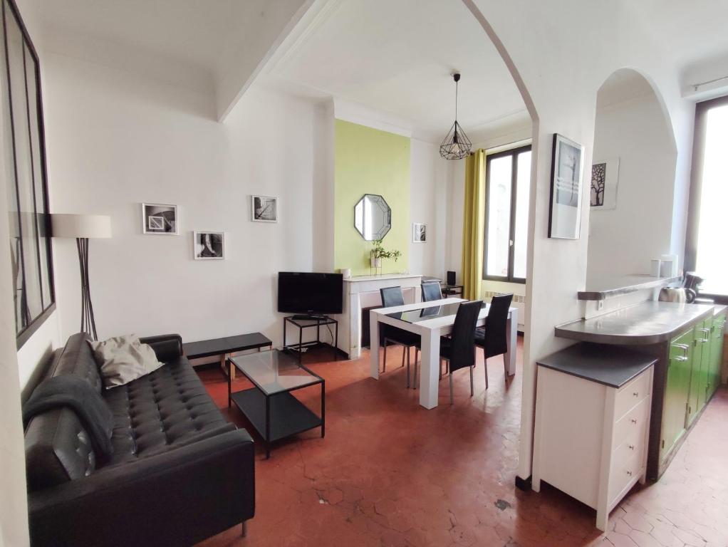 ein Wohnzimmer mit einem Sofa und einem Tisch in der Unterkunft Appartement typique entre la Gare et la Canebière in Marseille
