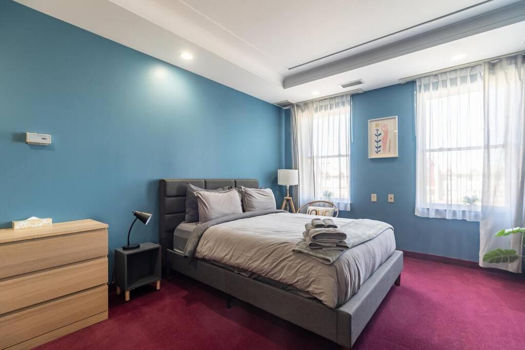 a blue bedroom with a bed and a dresser at Urban Nest Studios in Halifax