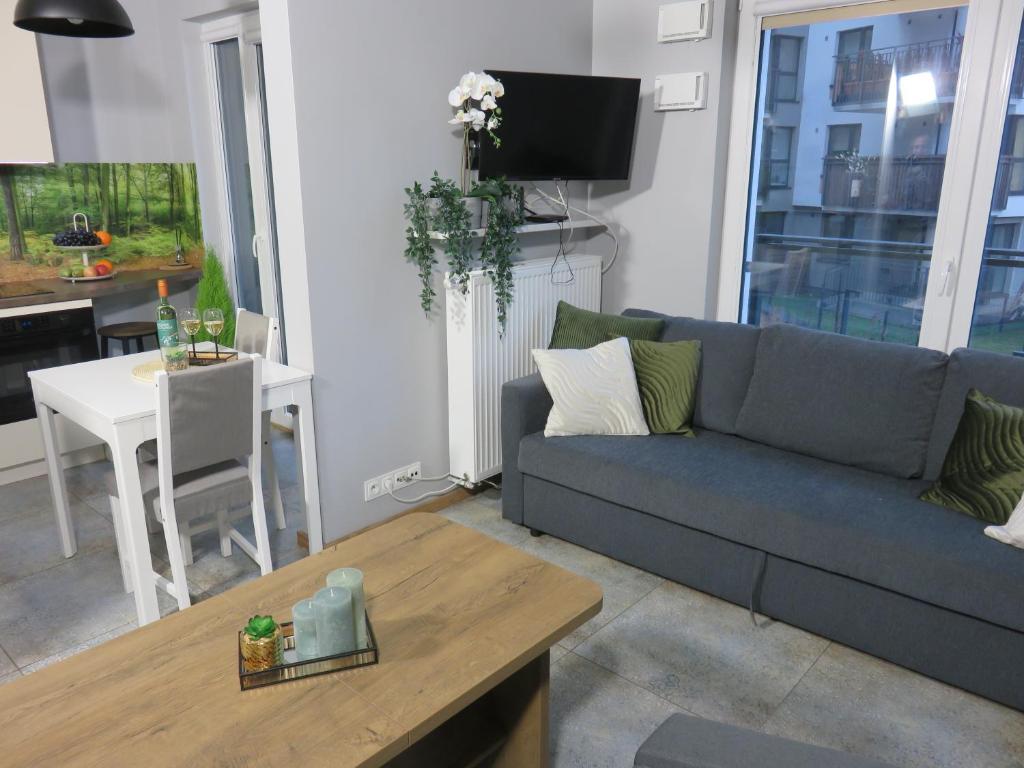 een woonkamer met een bank en een tafel bij Nowoczesny apartament z garażem i balkonem Mokotów in Warschau