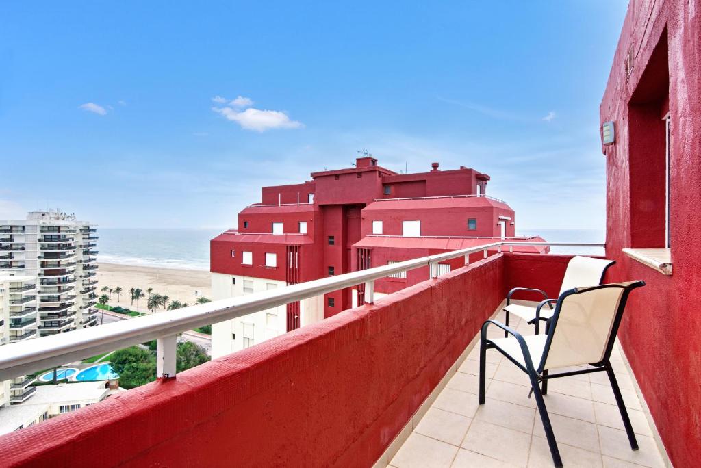 2 Stühle auf einem Balkon mit Blick auf den Strand in der Unterkunft Danio in Playa de Gandia