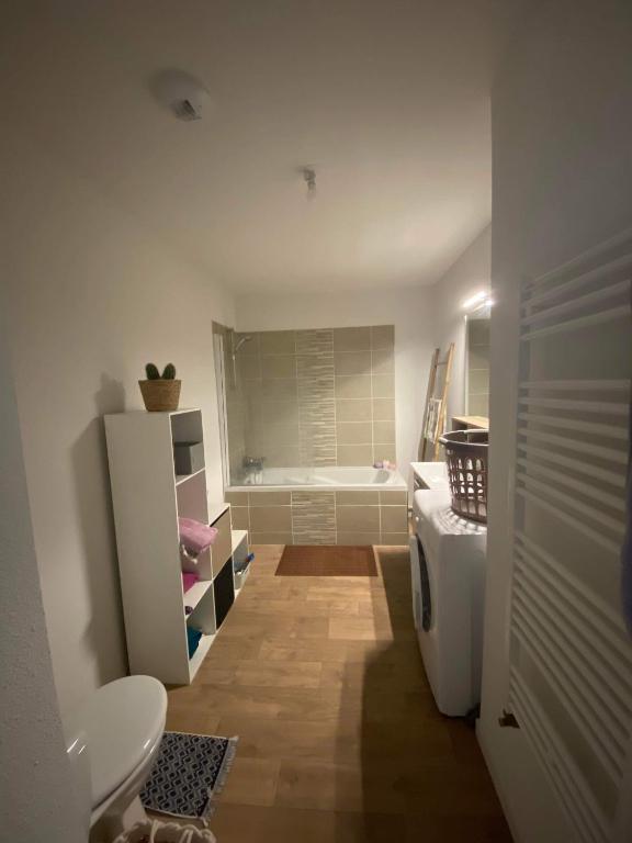 een badkamer met een bad, een toilet en een wastafel bij Appartement spacieux avec Parking bordeaux in Bordeaux