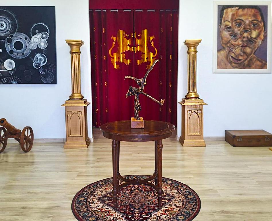 uma mesa com um vaso em cima numa sala com pinturas em Galeria Design Art em Florianópolis