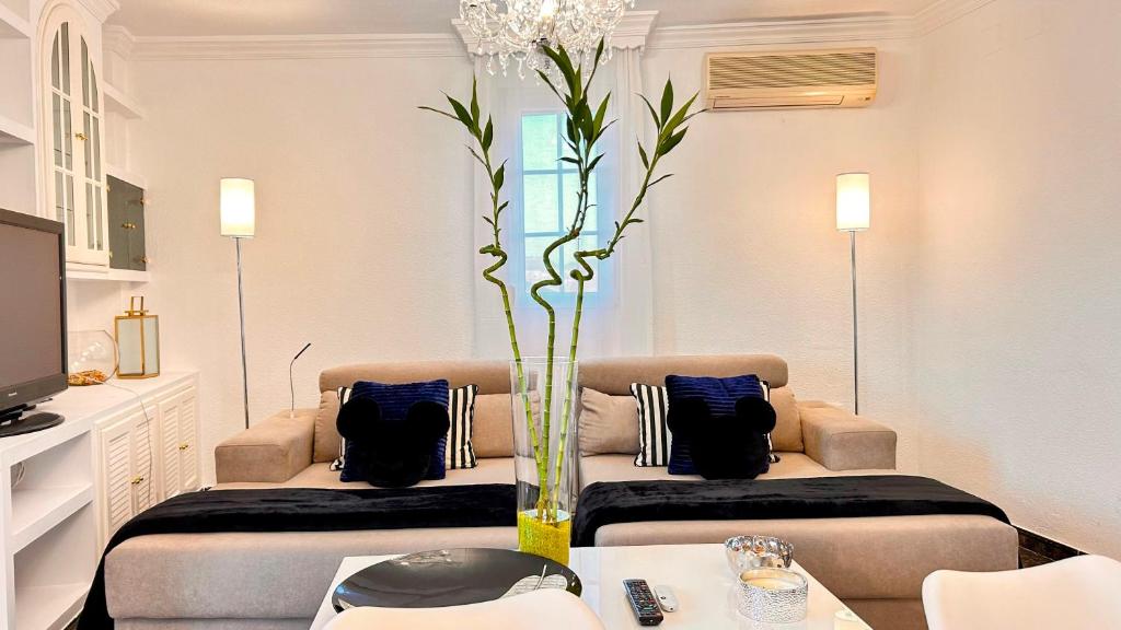 a living room with a couch and a vase with a plant at Íberos Royal in La Zubia