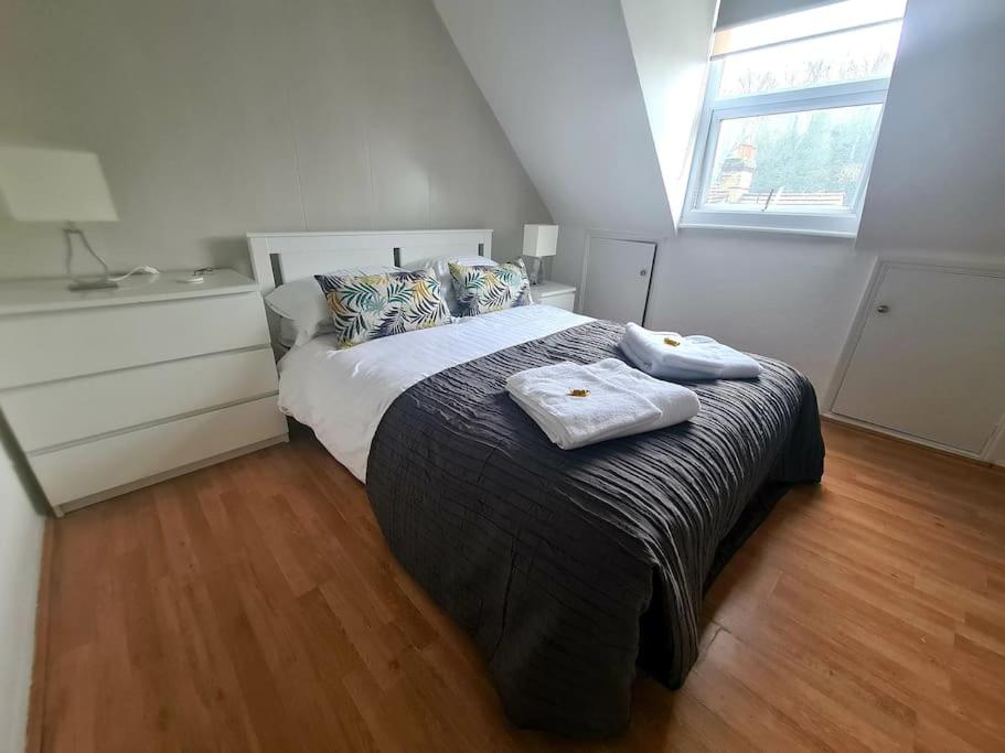 a bedroom with a bed with two towels on it at Split level luton town center flat in Luton