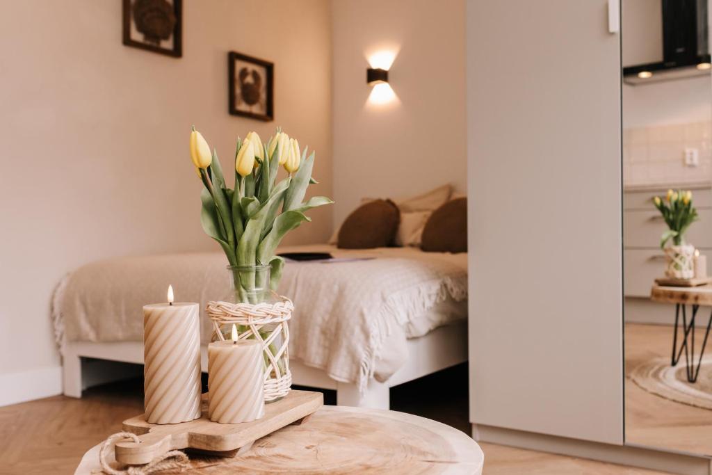 Habitación con cama y mesa con flores amarillas en Casa la Vida Beach House en Zandvoort