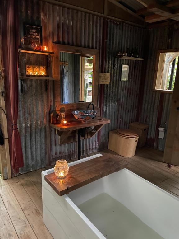 um quarto com uma banheira e uma mesa de madeira em The kauri Tree Pod - Off Grid Experience em Levin