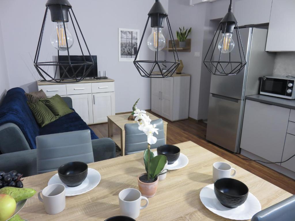ワルシャワにあるUroczy apartament dla 4 osóbのキッチン、リビングルーム(ダイニングルーム、木製テーブル付)